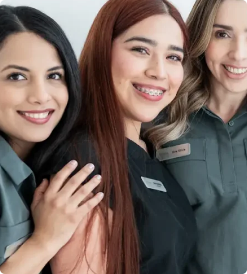 mujeres con ropa de dentista posando y sonriendo para la camara