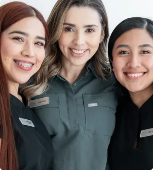 mujeres con ropa de dentista posando y sonriendo para la camara