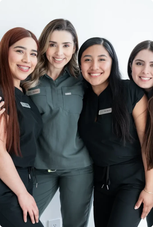 mujeres con ropa de dentista posando y sonriendo para la camara