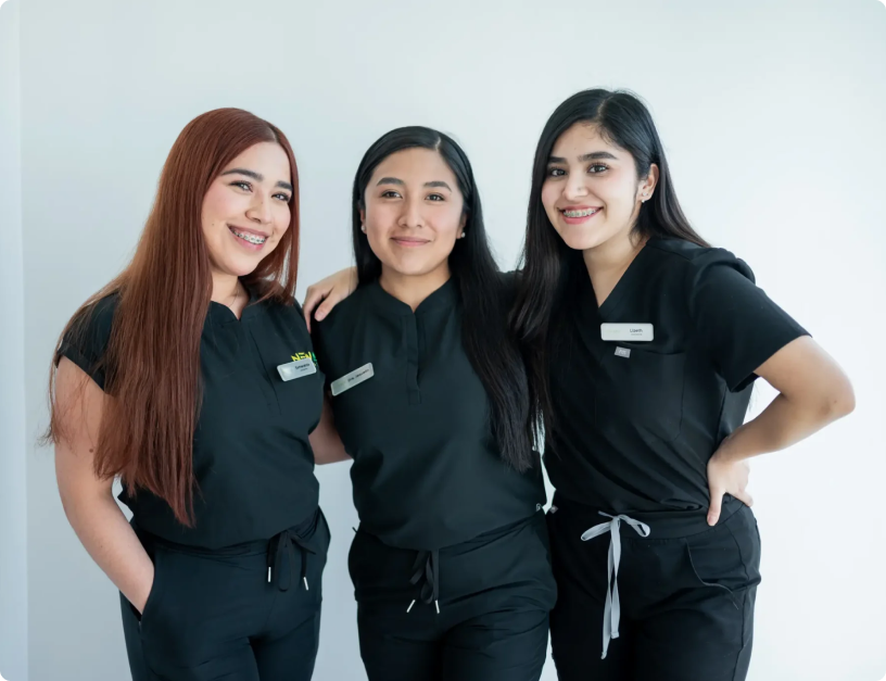 mujeres con ropa de dentista posando y sonriendo para la camara