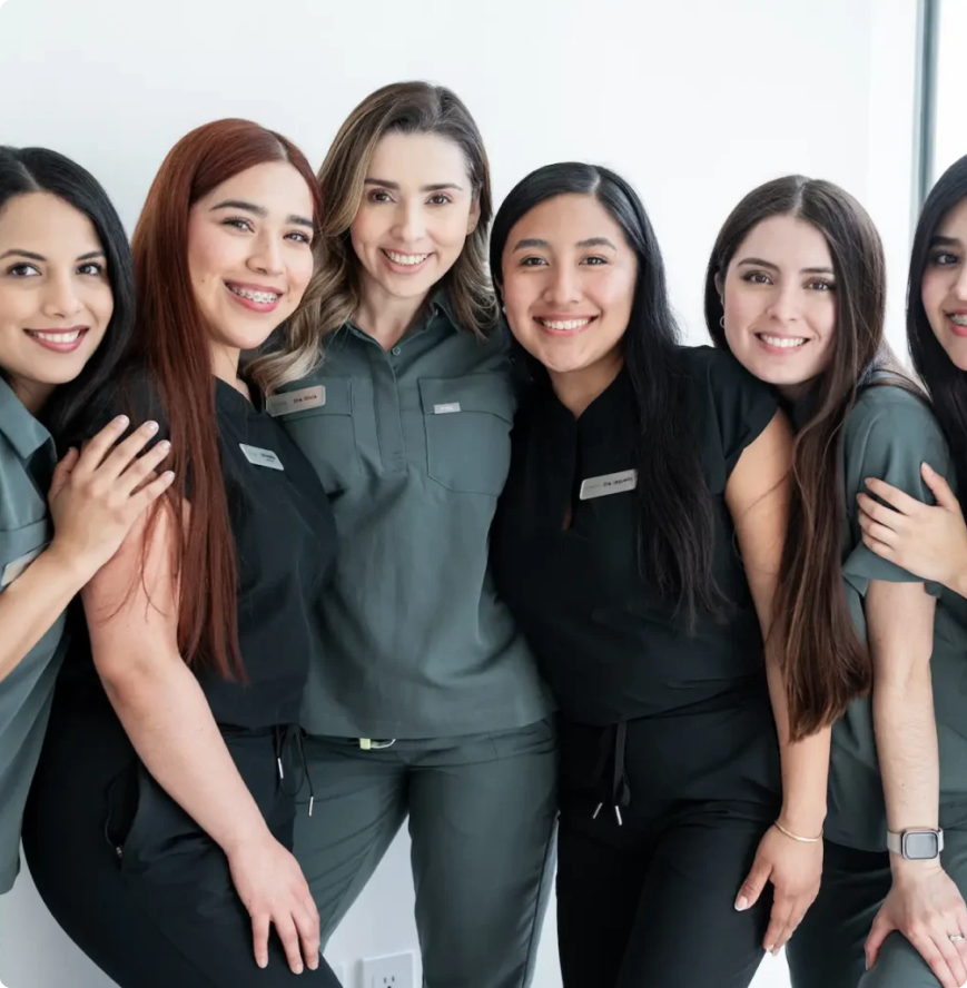 mujeres con ropa de dentista posando y sonriendo para la camara